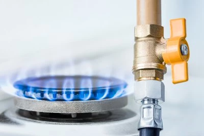 Brandende gaspit met blauwe vlam en afsluitkraan.